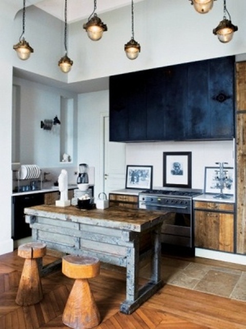 a stained wooden kitchen island looks very rough and contrasts the black upper cabinets
