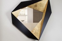 a fabulous faceted geometrically shaped mirror with gold and black timber parts is a fantastic artwork, not just a usual mirror