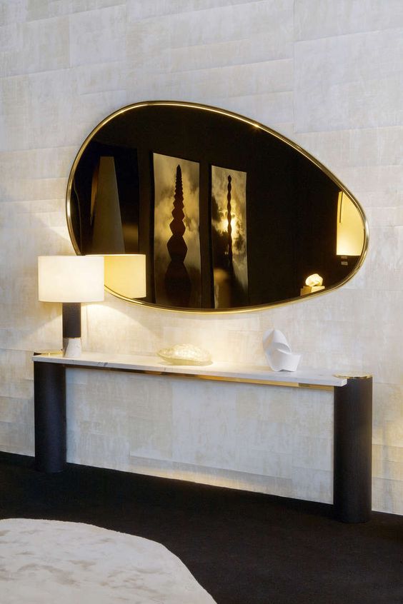 A beautiful gold egg shaped mirror will add warm glow to the space and will make it softer with its shape and cool look
