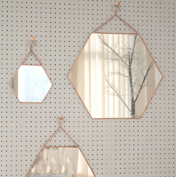 An arrangement of hexagon shaped mirrors on chain is a lovely gallery wall that will bring shape and interest to the space, and a shiny touch