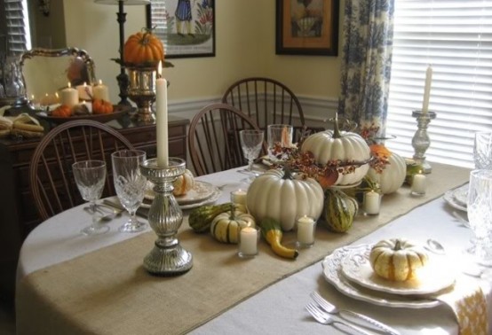 a neutral Thanksgiving tablescape with neutral linens, white porcelain, faux and nautral pumpkins, silver candleholders and candles