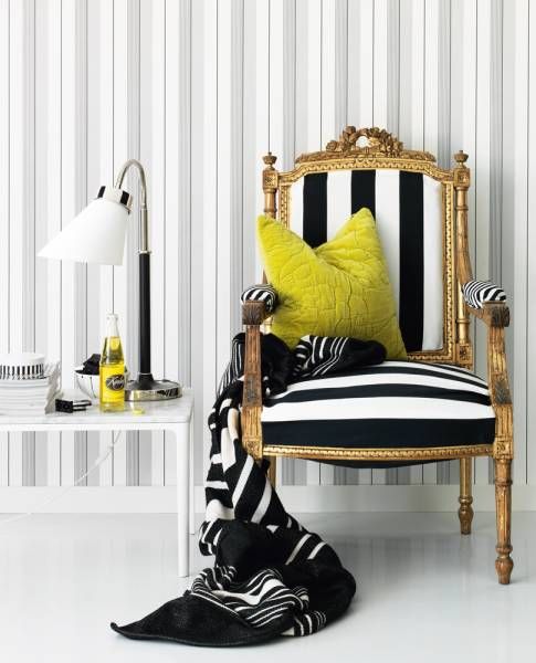 grey and white striped wallpaper, a striped antique chair and a white coffee table with a white table lamp