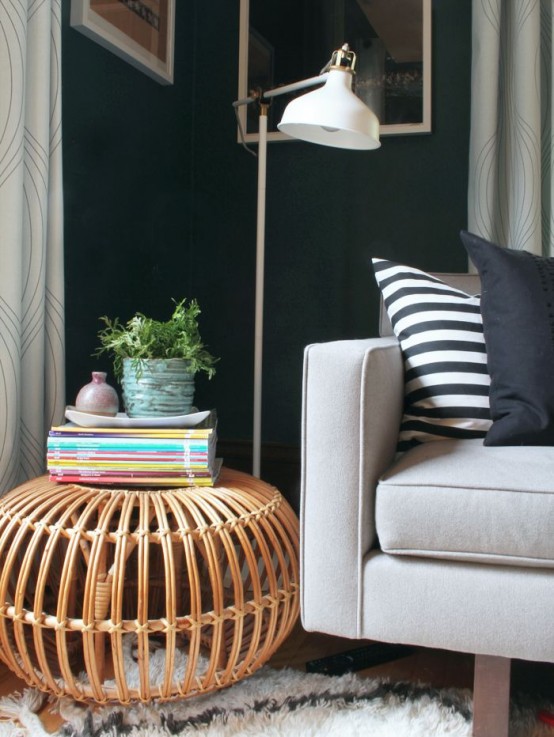 a cozy and chic reading nook with a comfy sofa with pillows, a Ranarp lamp and a rattan table with potted greenery