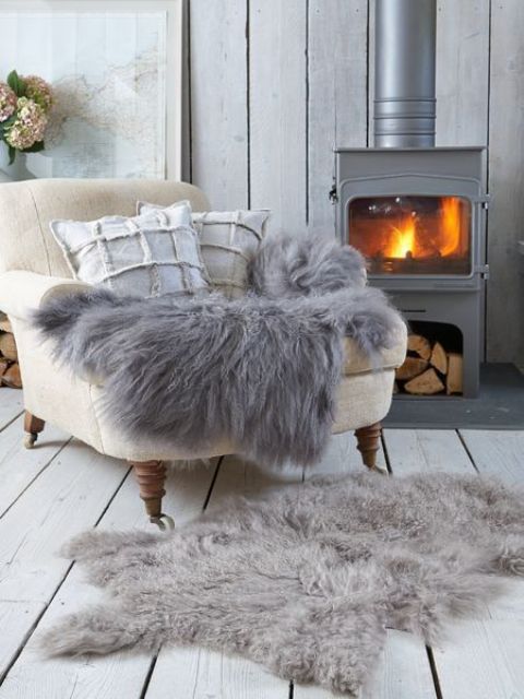 A vintage inspired metal hearth with a chair by it and some faux fur is the greatest nook to spend some time