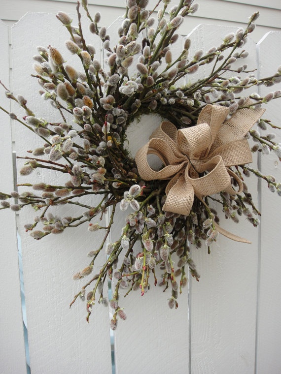 A spring wreath made of willow and accented with a burlap bow will bring a strong rustic spring feel to your porch