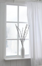 a white porcelain vase with willow is a cool idea for decorating your windowsills