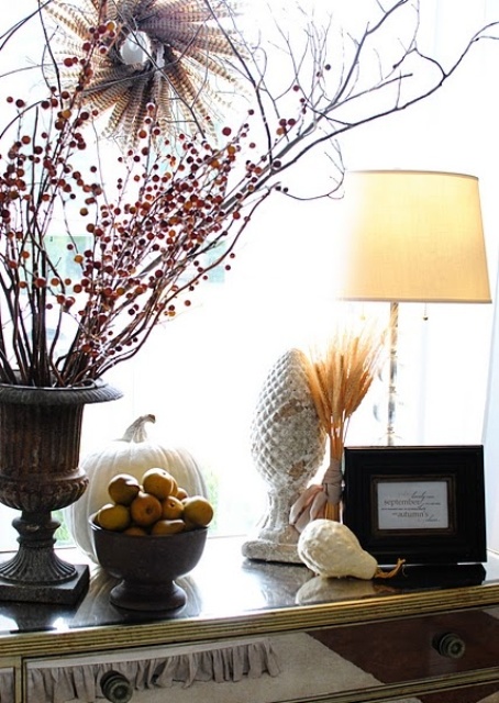 a fall arrangement with branches and berries in a vintage urn, pears in a bowl and some wheat