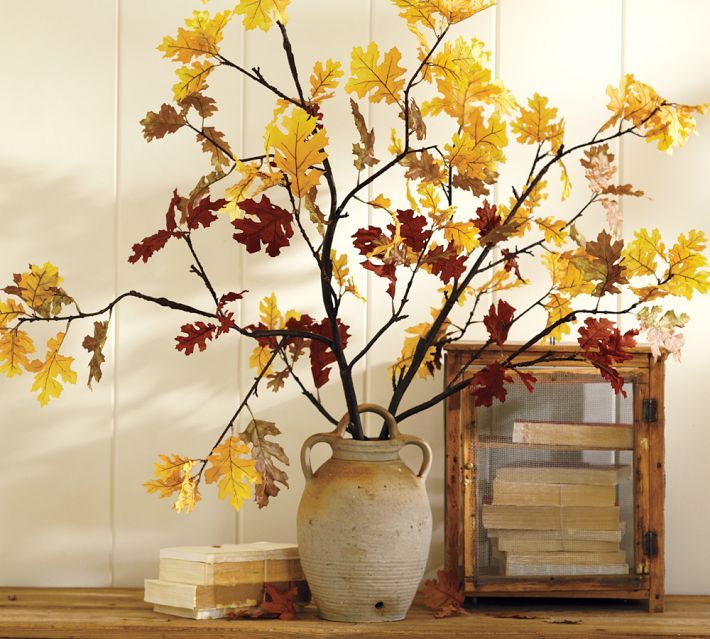 An antique inspired vase with branches and yellow leaves on them for bold fall decor