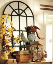 a vase with bright fall leaf branches and fake birds for vintage-inspired and elegant fall decor