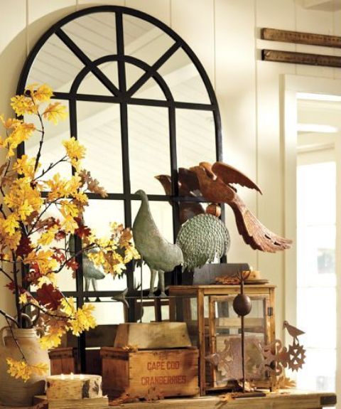 A vase with bright fall leaf branches and fake birds for vintage inspired and elegant fall decor