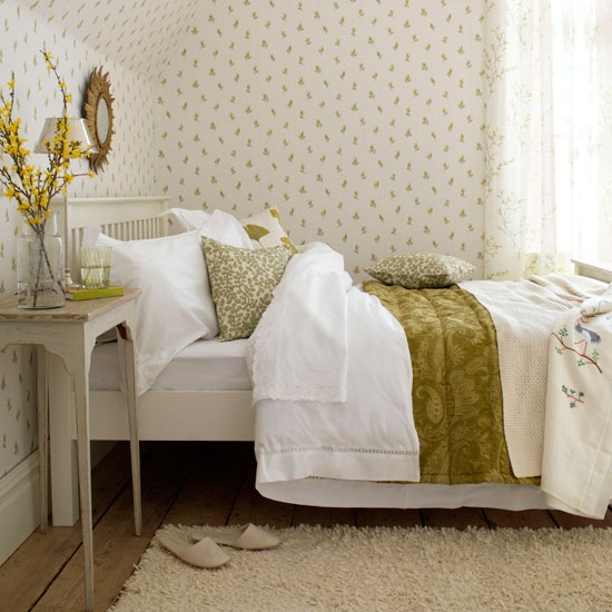 floral wallpaper, botanical print bedding and some blooming branches make the bedroom look fresh and spring-like