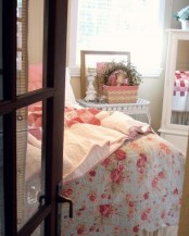 a shabby chic spring bedroom with bright floral and botanical print bedding, a greenery wreath and a bold basket