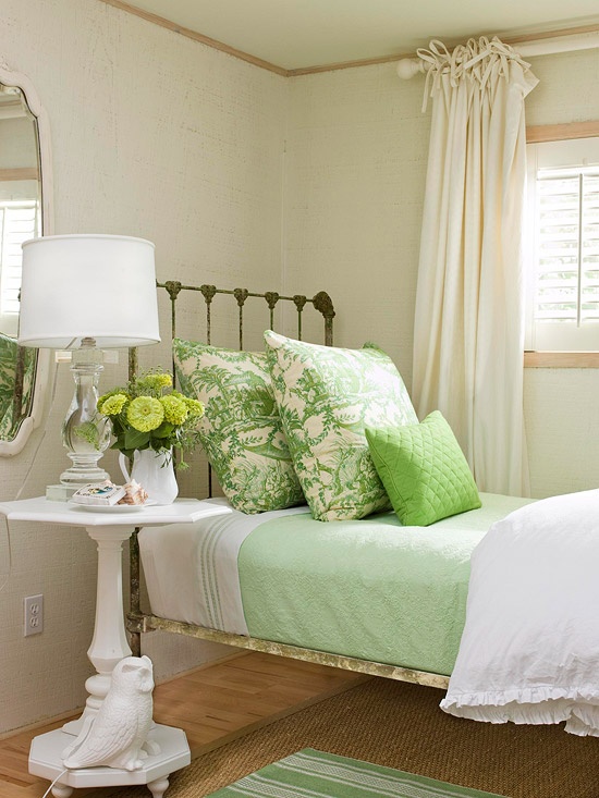 botanical print pillows and brigth green bedding and green blooms make the bedroom look fresh and bold