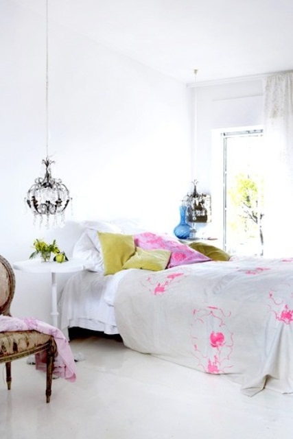 bright pink and mustard touches and blooming branches make the white bedroom fresh and bold for spring
