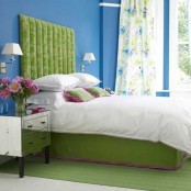 a bright bedroom with bold blue walls, a neon green bed and rug and floral curtains feels very bold and spring-summer