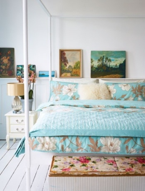 Bright and colorful bedding, bright artworks and a floral bench make the neutral bedroom feel more spring like