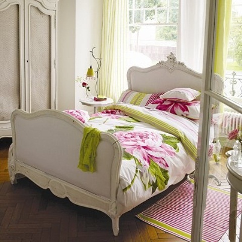 An elegant bedroom with bright green and pink touches, with floral patterns make the space feel veyr bold and spring like