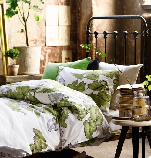 Botanical print bedding and potted greenery make the bedroom fresh and spring like