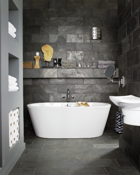 A contemporary bathroom clad with dark stone like tiles completely to make the space more eye catchy and chi