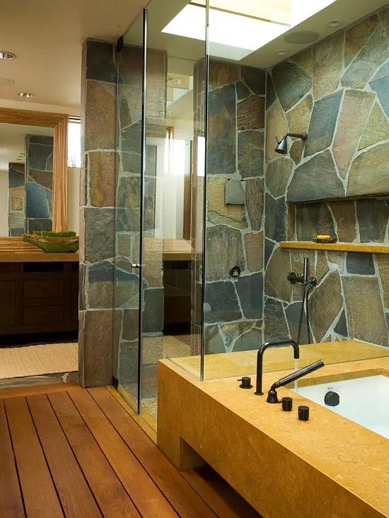 A contemporary bathroom with a touch of rustic chic   a stone wall and stained wooden floors